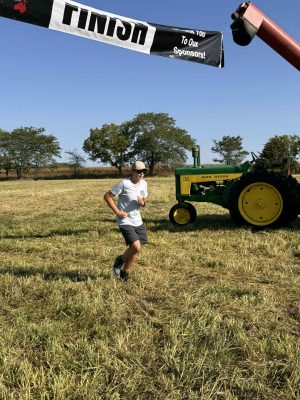 Runner crosses under Finish banner at the 2025 annual Project Nic Run for Shelter 5k