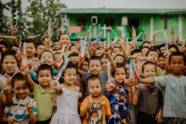 Kids show off their new toothbrushes at a shelter location