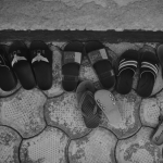 sets of small sandals on a cobblestone plaza