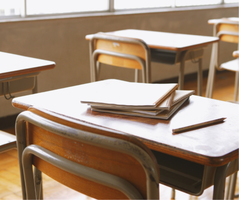 A child's classroom desk in warm natural light, representing steady care and the impact of consistent support
