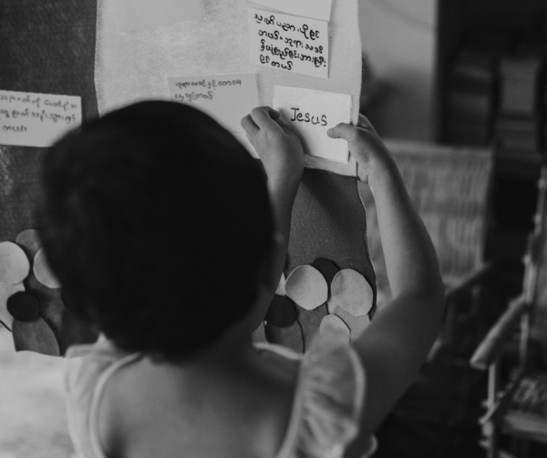 A young girl adds a note to a presentation board